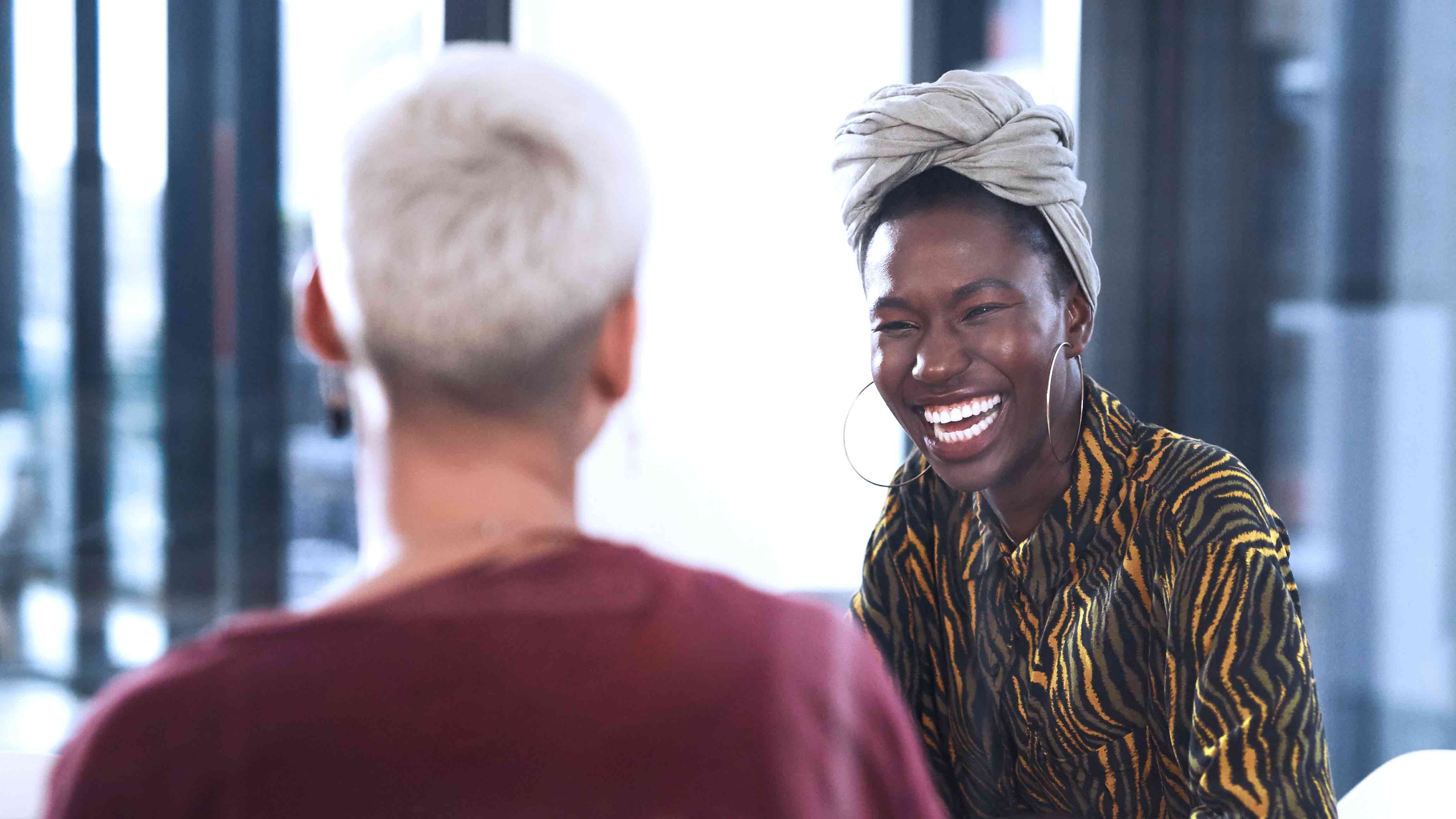 Kaksi henkilöä keksutelevat keskenään toimistossa. 