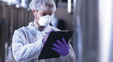 Laboratoriotyöntekijä merkitsee ylös tietoja kirjoituslevylle.