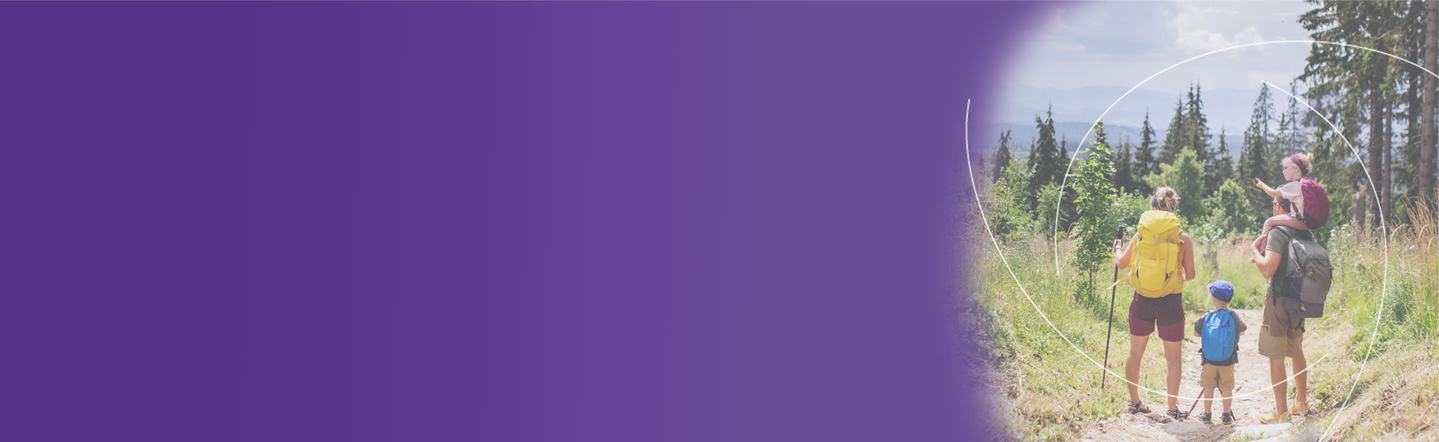 Nelihenkinen perhe patikoimassa luonnossa. Taustalla havumetsä